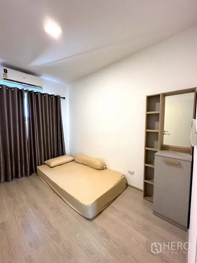 Townhouse for rent in Bang Phli, Samut Prakan - Third bedroom with low mattress, cabinet and blackout curtains.