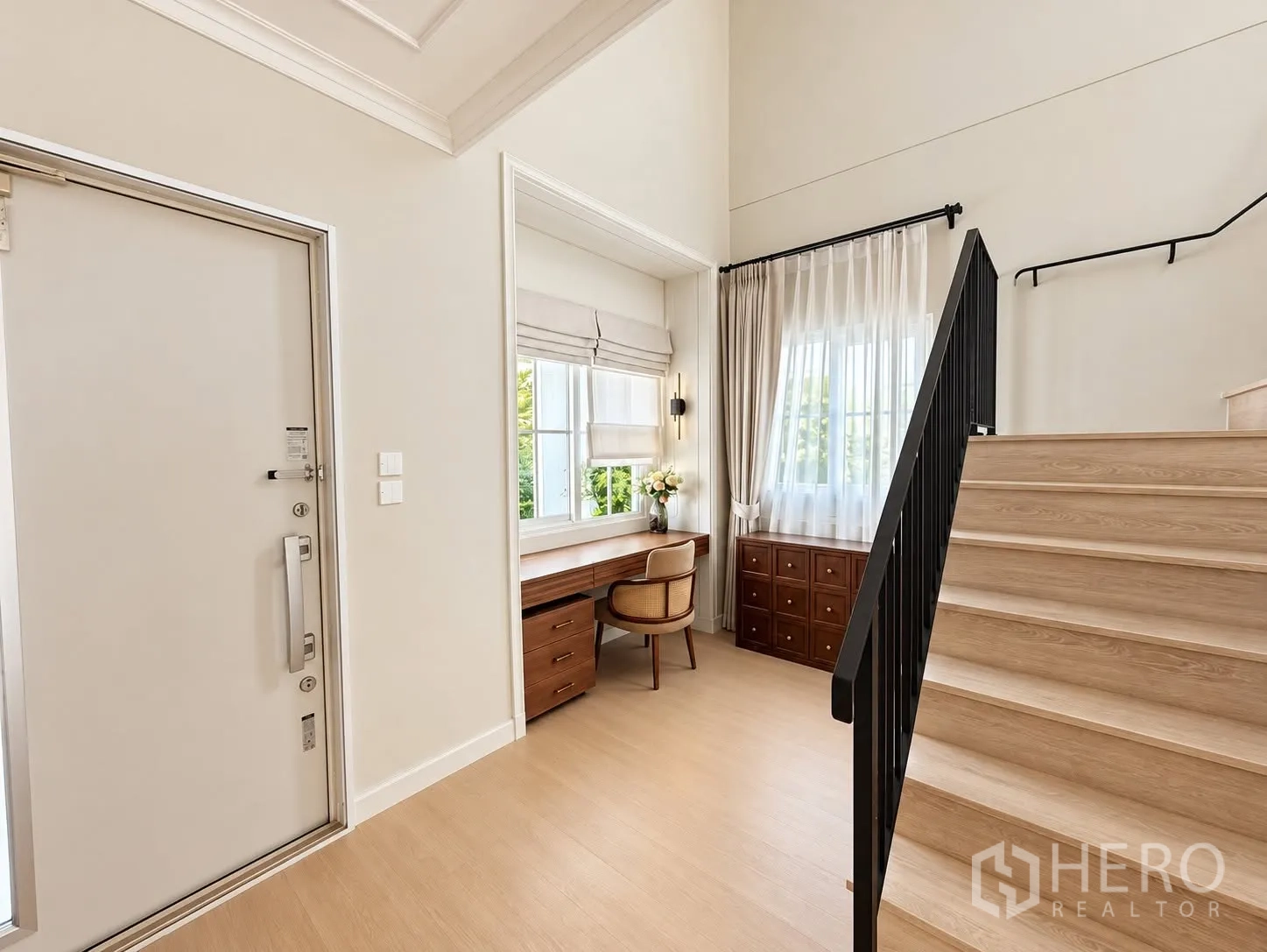 独栋房屋 for rent in Bang Phli, Samut Prakan - 玄关带窗边书桌与黑色栏杆楼梯。