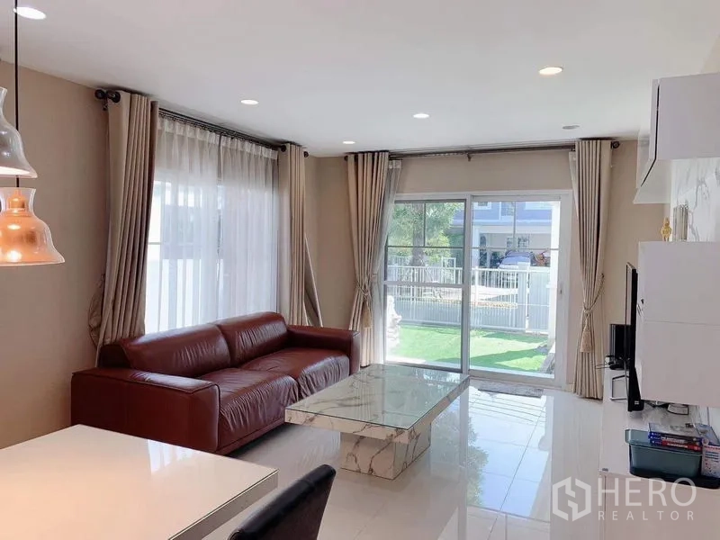 บ้าน ให้เช่าหรือขายในBang Phli, Samut Prakan - ห้องนั่งเล่นรับแสงธรรมชาติ เห็นสวนผ่านประตูกระจกบานเลื่อน