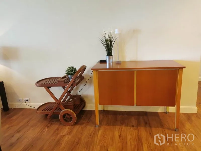 公寓 出租在Watthana, Bangkok - 木地板一角，摆有木制餐车与小型边柜。