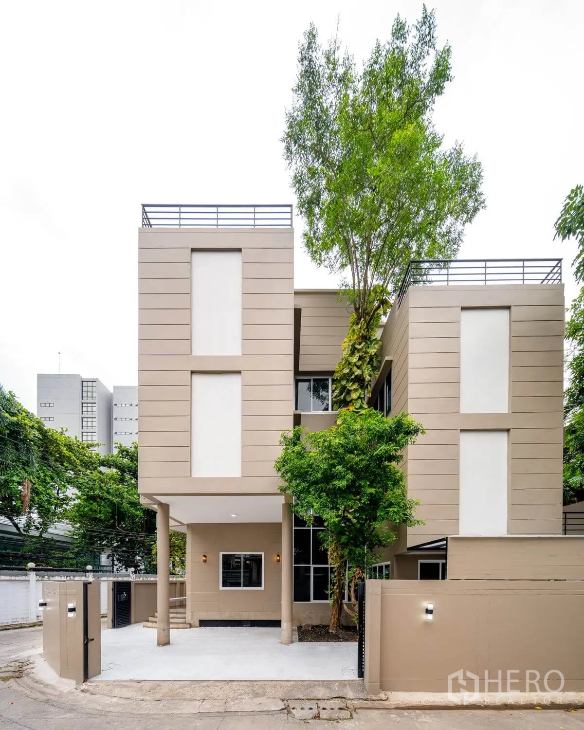 บ้านเดี่ยว for rent or sale in Chatuchak, Bangkok - ภายนอกบ้านเดี่ยวสามชั้นสมัยใหม่ มีทางรถเข้า ต้นไม้ และกำแพงรอบรั้ว