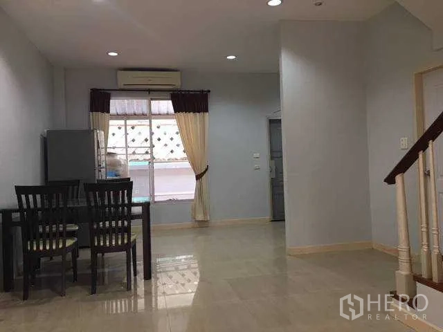 带办公室的家 出租在Wang Thonglang, Bangkok - 曼谷王通朗区家庭办公楼的开放式客餐厅，瓷砖地面、餐桌与窗帘窗户。
