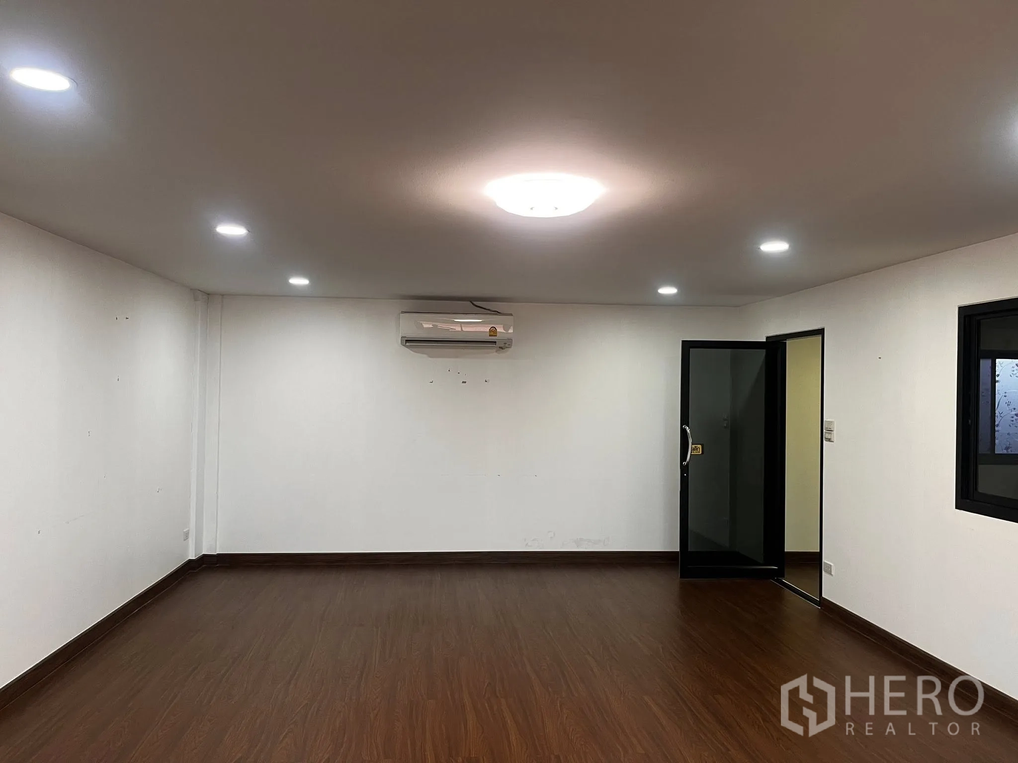 Warehouse for rent in Lat Phrao, Bangkok - Second office room with air conditioning and a glass door entry.