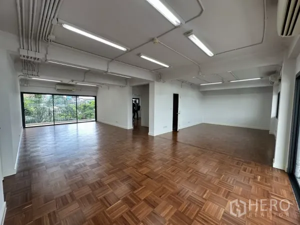 สำนักงาน ให้เช่าในWatthana, Bangkok - โซนทำงานกว้าง เพดานเดินท่อไฟแบบลอย พื้นไม้ และหน้าต่างบานใหญ่เห็นวิวร่มรื่น.