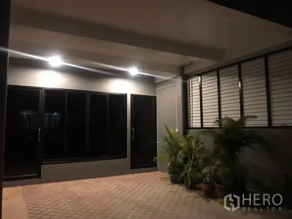 带办公室的家 出租在Bang Rak, Bangkok - 夜间的前庭罩棚，推拉玻璃门与盆栽。
