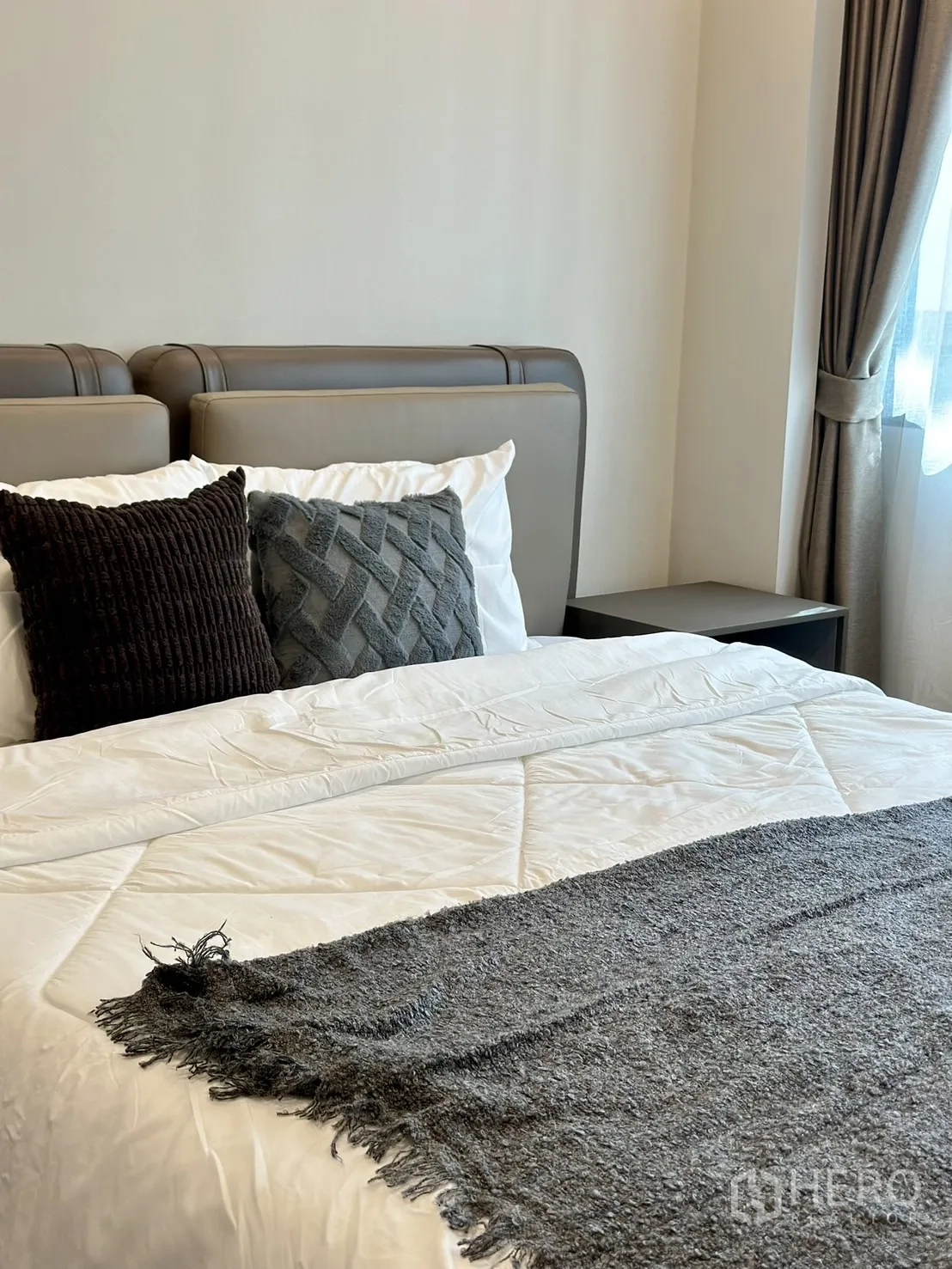 Detached House for rent or sale - Cozy bedroom bed close-up with gray throw and textured pillows beside curtained window.