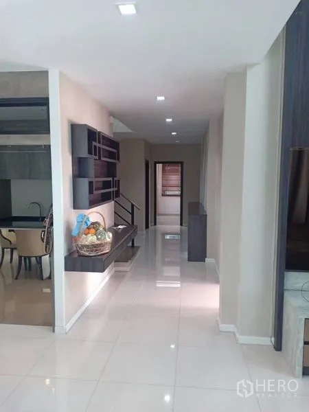 Detached House for rent in Thanyaburi, Pathum Thani - Ground-floor corridor connecting living area to kitchen with wall shelving and lighting.
