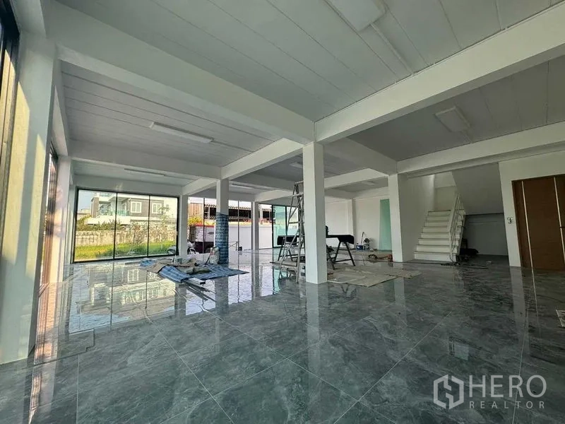 Home Office for rent in Don Mueang, Bangkok - Ground-floor lobby under light renovation with glossy gray tiles and staircase.