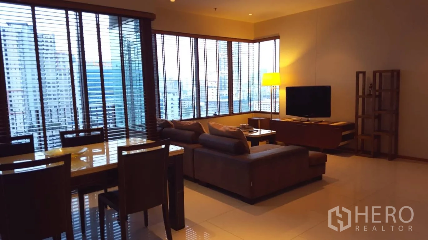 Condominium for rent or sale in Khlong Toei, Bangkok - Open-plan living and dining area with floor-to-ceiling windows over the skyline.