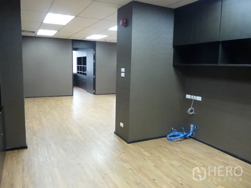 Office Space for sale in Watthana, Bangkok - Spacious workspace with suspended ceiling lights, wall shelving and network cabling points.