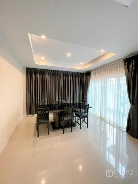 บ้าน ขายในBang Phli, Samut Prakan - ห้องทานอาหารแบบโอเพ่นสเปซ เพดานซ่อนไฟ และหน้าต่างสูงจรดพื้นพร้อมผ้าโปร่ง