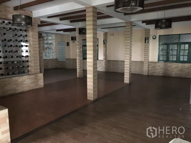 Retail Space for rent in Khlong Toei, Bangkok - Open-plan hall with multiple columns, wood-look flooring, feature lighting and large windows.