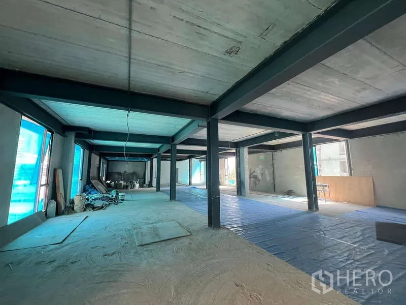 Retail Space for rent in Pathum Wan, Bangkok - Large retail unit under renovation with materials on one side and bright windows along the facade.