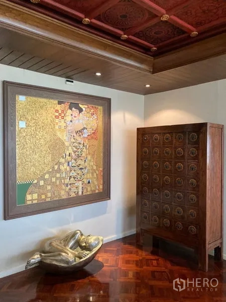 คอนโด ให้เช่าในBang Rak, Bangkok - มุมศิลปะพร้อมภาพวาดทอง ตู้ไม้แกะสลัก และฝ้าไม้ลายบนพื้นเงา
