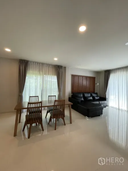 独立式住宅 出租在Bang Phli, Samut Prakan - 四人餐桌旁的客厅区域，通高纱帘采光好。