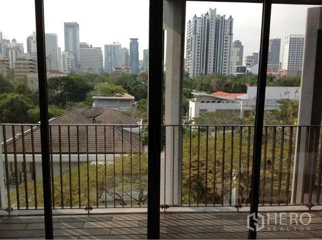 公寓 出租或出售在Watthana, Bangkok - 阳台栏杆外望绿树与曼谷天际线