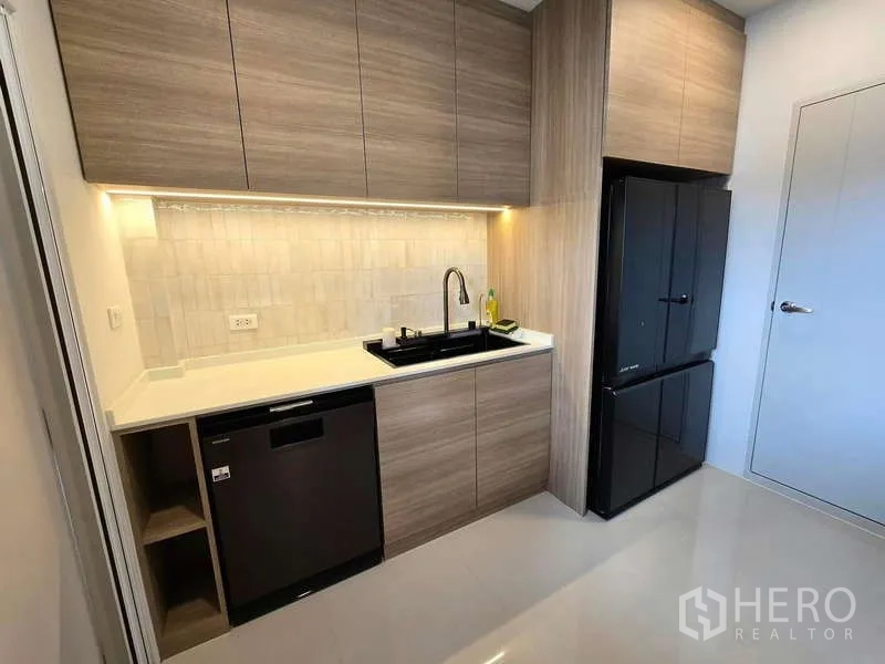 独立式住宅 出租在Bang Phli, Samut Prakan - 现代备餐厨房，木质橱柜，黑色冰箱和洗碗机。