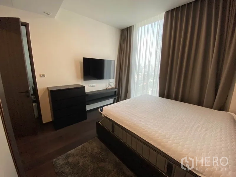 คอนโด ให้เช่าในWatthana, Bangkok - ห้องนอนพร้อมทีวีและตู้ลิ้นชัก ข้างหน้าต่างสูงชมวิวสกายไลน์กรุงเทพฯ