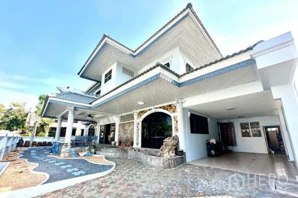 Detached House for rent in Taling Chan, Bangkok - Side perspective of the facade with covered carport and landscaped entry path.