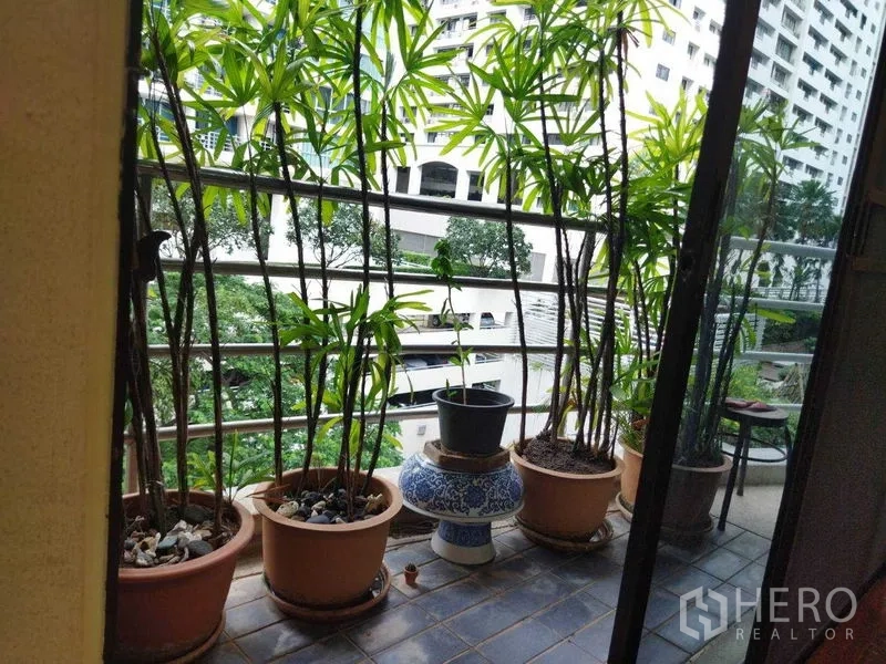 公寓 出租在Pathum Wan, Bangkok - 阳台放置赤陶花盆与绿植，俯瞰庭院和楼群。