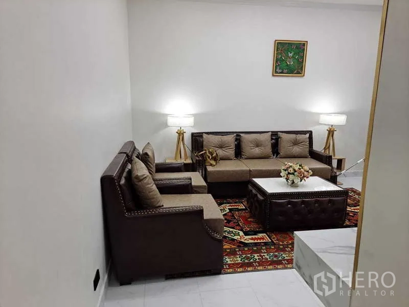 公寓 出租在Khlong Toei, Bangkok - 温馨会客区，三人沙发、扶手椅与软包茶几。