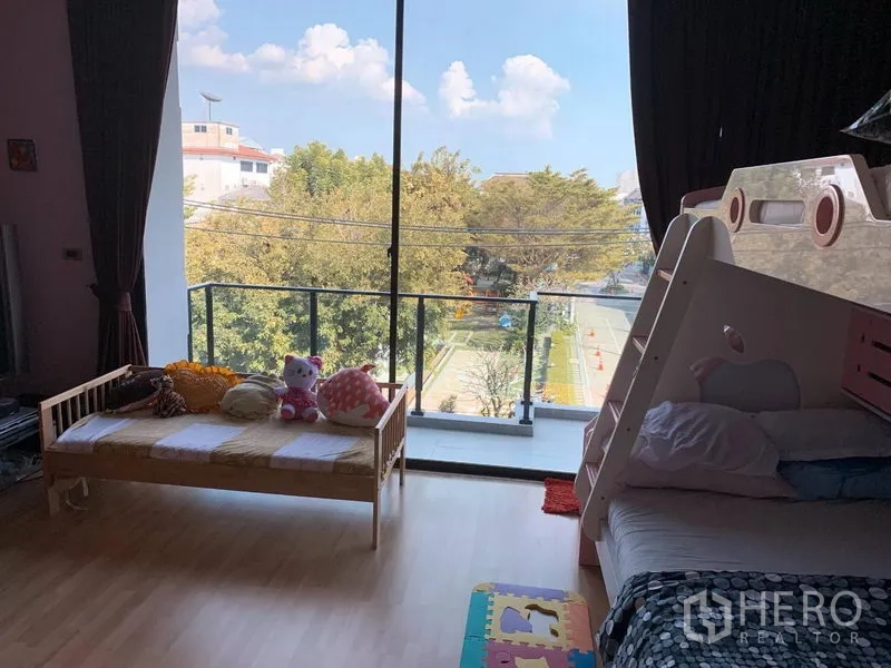 Townhouse for rent or sale in Chatuchak, Bangkok - Spacious kid’s bedroom with bunk bed and full‑height windows opening to balcony.