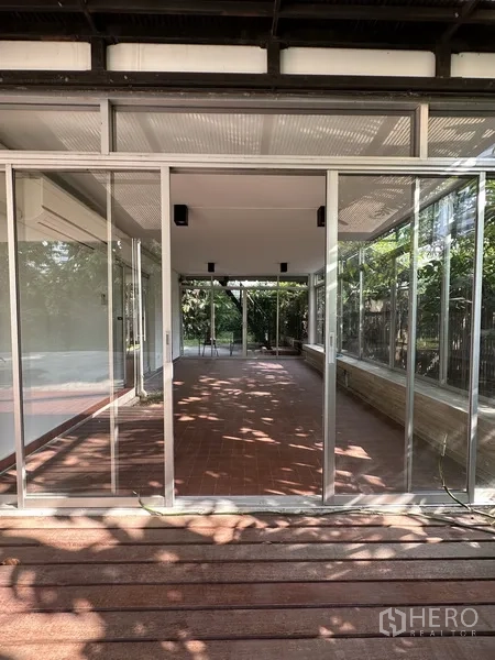 独立式住宅 出租在Khlong Toei, Bangkok - 封闭式玻璃露台，红色地砖与前方木平台