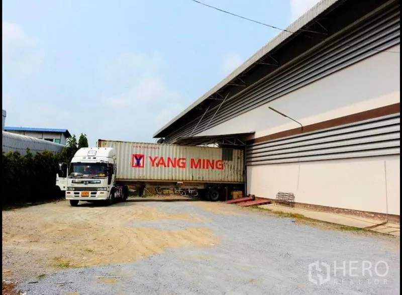 Warehouse for rent in Nakhon Pathom - Container truck maneuvering at the warehouse’s covered loading area and wide yard.