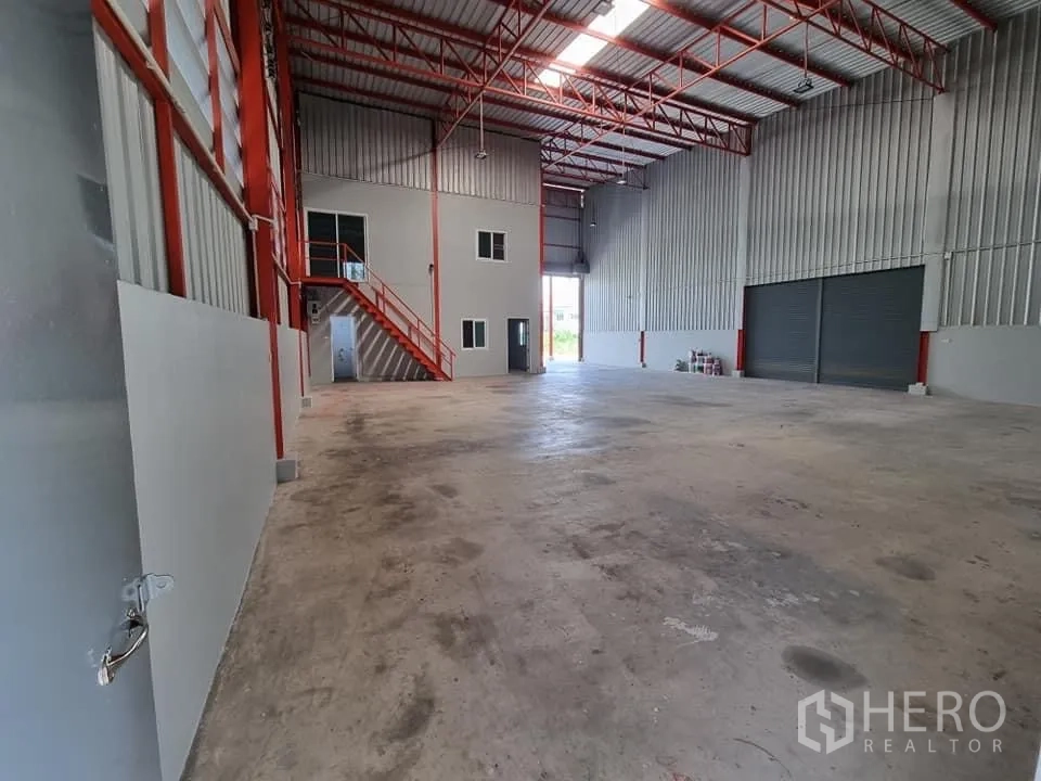 Warehouse for rent in Lam Luk Ka, Pathum Thani - Open concrete floor area with high roof, skylights and wide loading access.