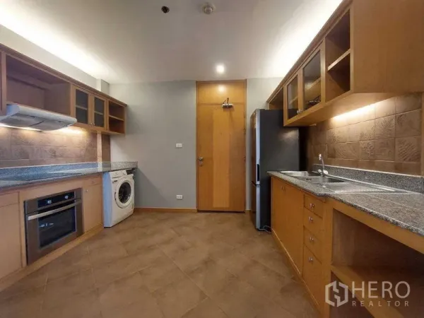 Apartment for rent - Spacious kitchen with wood cabinetry, granite countertops, built-in oven, washing machine and refrigerator.