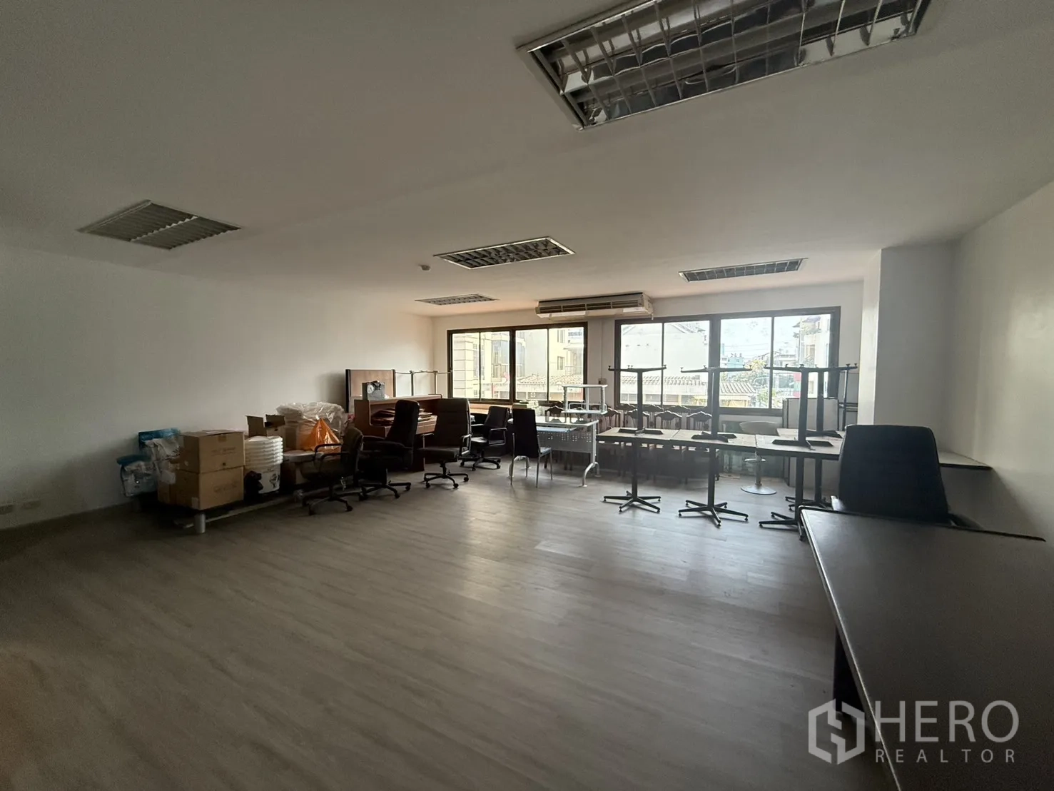 办公空间 for rent in Sathon, Bangkok - 简装办公室，白色墙面、复合地板与网格灯，通长窗户带来自然采光。