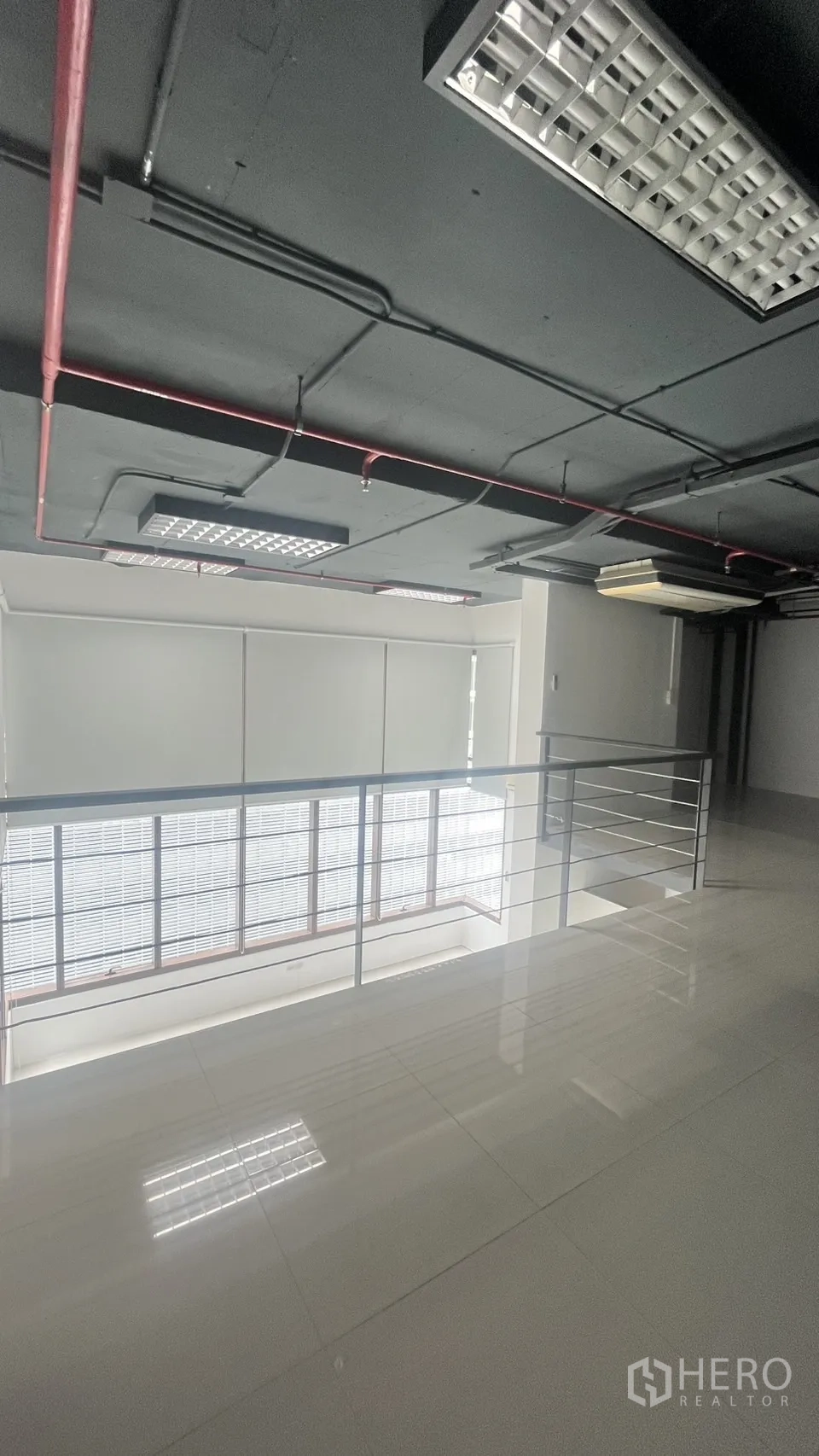 Office Space for rent in Khlong Toei, Bangkok - Loft area overlooking the double-height zone with large windows and roller blinds.