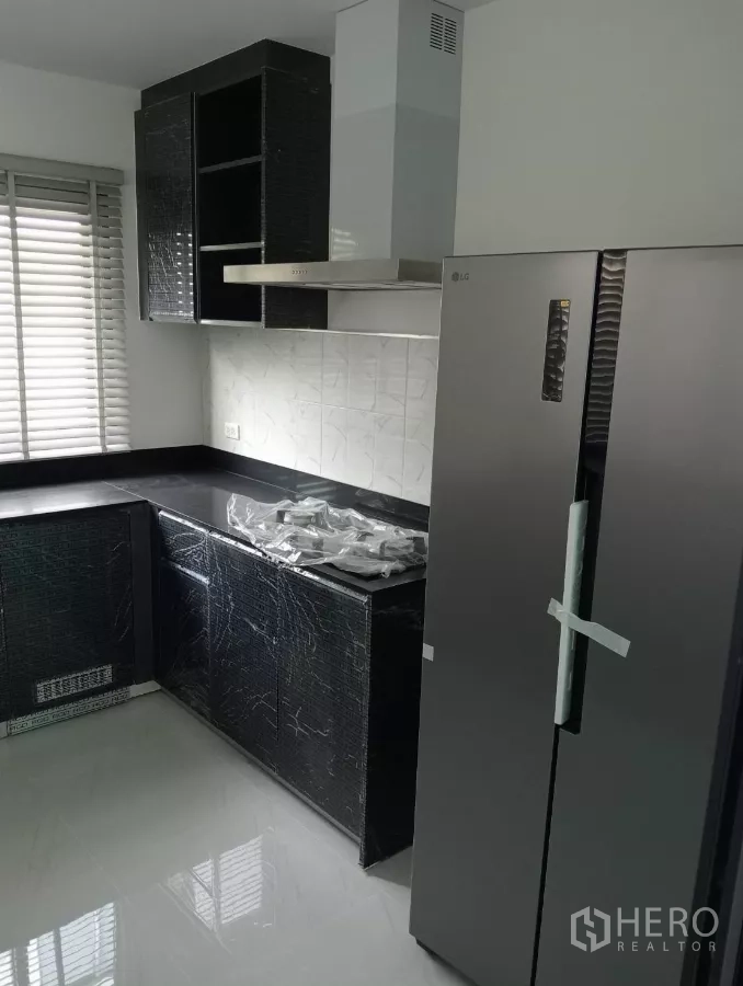 Detached House for rent in Bang Phli, Samut Prakan - Fitted kitchen with black countertops, stove, hood and large refrigerator.