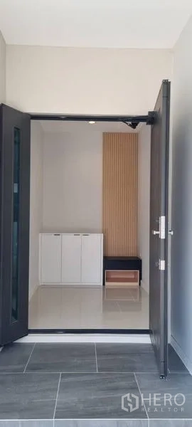 Detached House for rent in Saphan Sung, Bangkok - Front entrance foyer with double doors, shoe cabinet, and vertical wood accent panel.