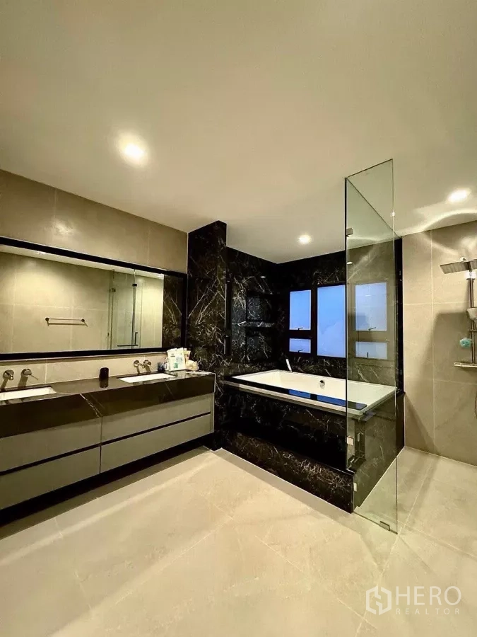 Detached House for sale in Saphan Sung, Bangkok - Contemporary bathroom featuring black marble tub surround, glass shower and double vanity.
