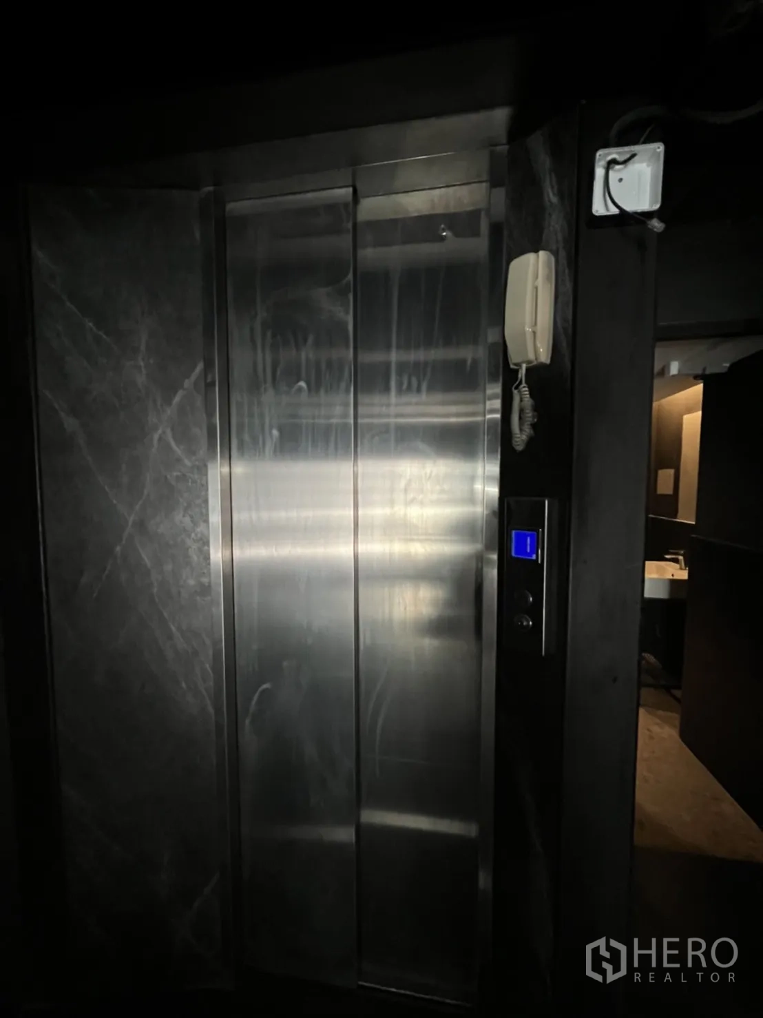 Home Office for rent or sale in Khlong Toei, Bangkok - Stainless-steel passenger elevator set into a dark marble wall.