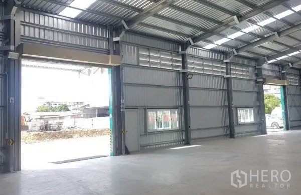 Warehouse for rent in Mueang Nonthaburi, Nonthaburi - Multiple loading bay doors and windows along the side wall for ventilation and access.