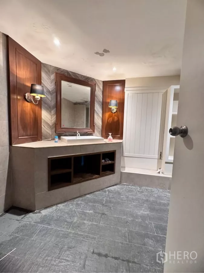Retail Space for rent in Watthana, Bangkok - Vanity area with large mirror, wall sconces and stone countertop.