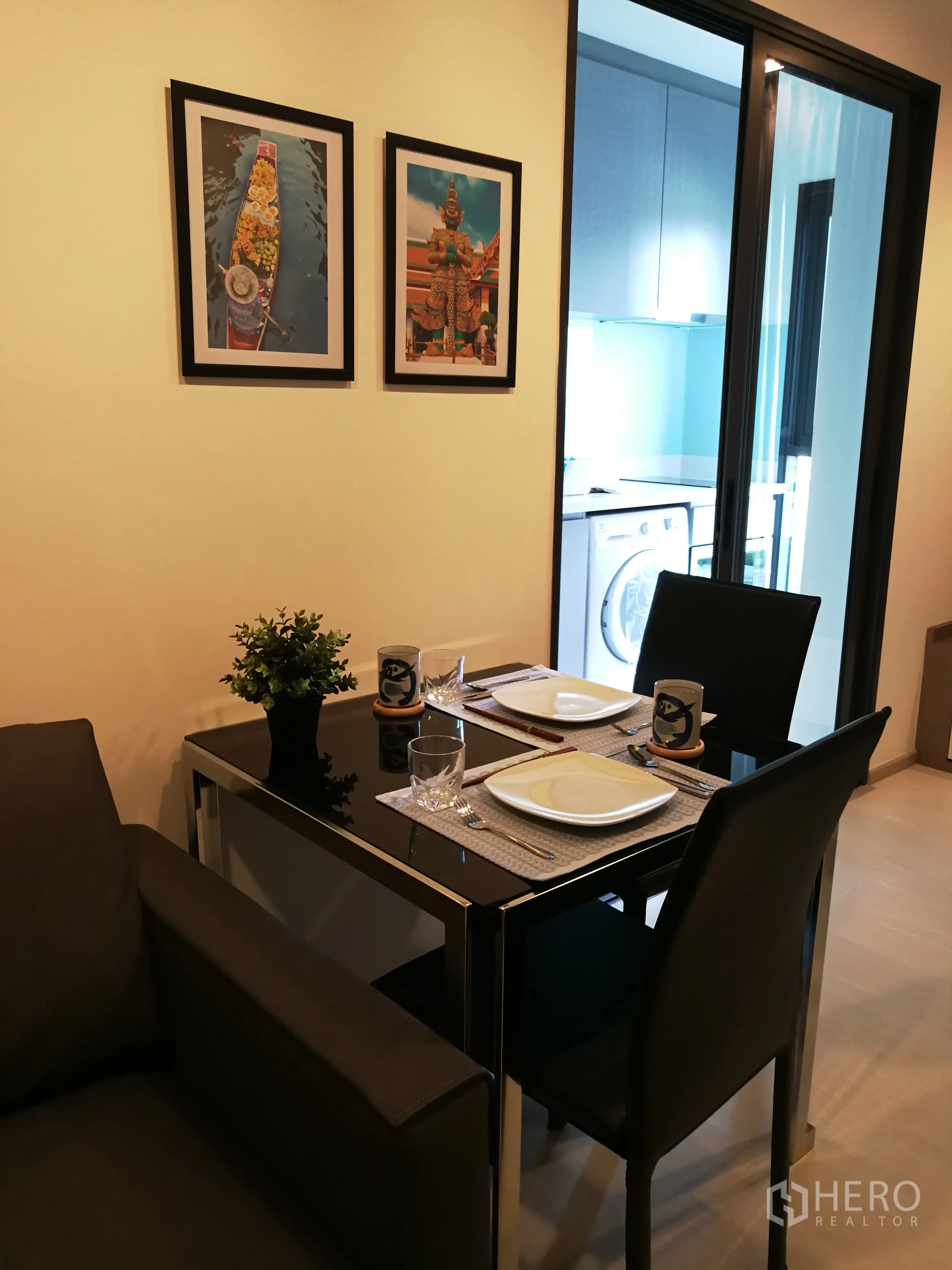 公寓 出租在Khlong Toei, Bangkok - 双人餐区，旁为通向独立厨房的玻璃推门，可见洗衣机。