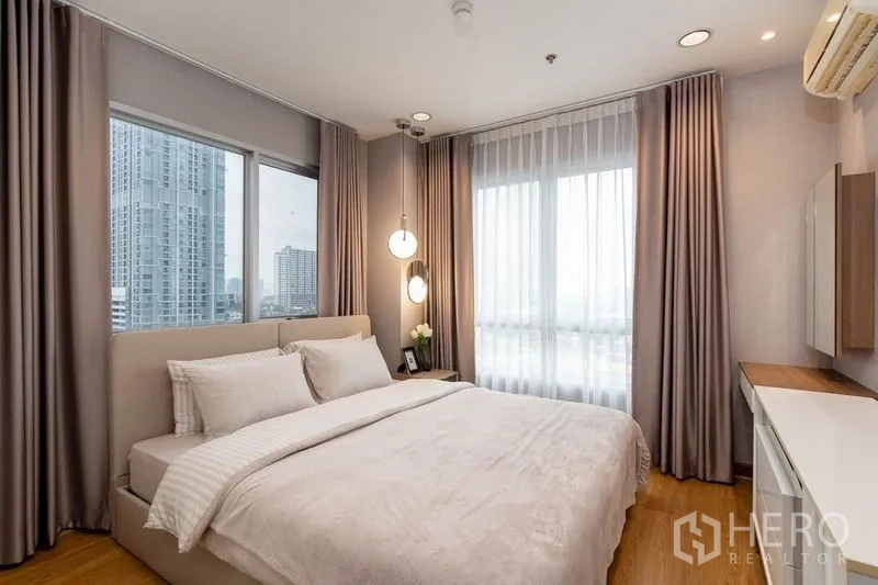公寓 出租在Phaya Thai, Bangkok - 转角主卧，双面窗与纱帘，吊灯点缀