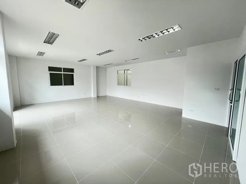 Warehouse for rent in Phra Samut Chedi, Samut Prakan - Bright tiled office room with fluorescent ceiling lights and windows.
