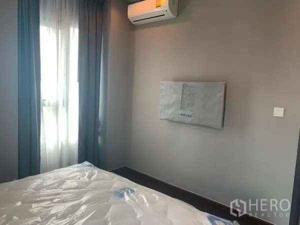 คอนโด ให้เช่าในWatthana, Bangkok - ห้องนอนรองพร้อมเครื่องปรับอากาศ จุดติดทีวีติดผนัง และหน้าต่างพร้อมผ้าม่าน.