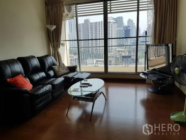 公寓 出租在Ratchathewi, Bangkok - 客厅配黑色皮沙发与玻璃茶几，落地窗眺望城市天际线