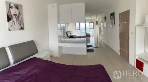 Condominium for sale in Khlong Toei, Bangkok - Spacious bedroom with built-in dresser, mirror wardrobes and a city view.