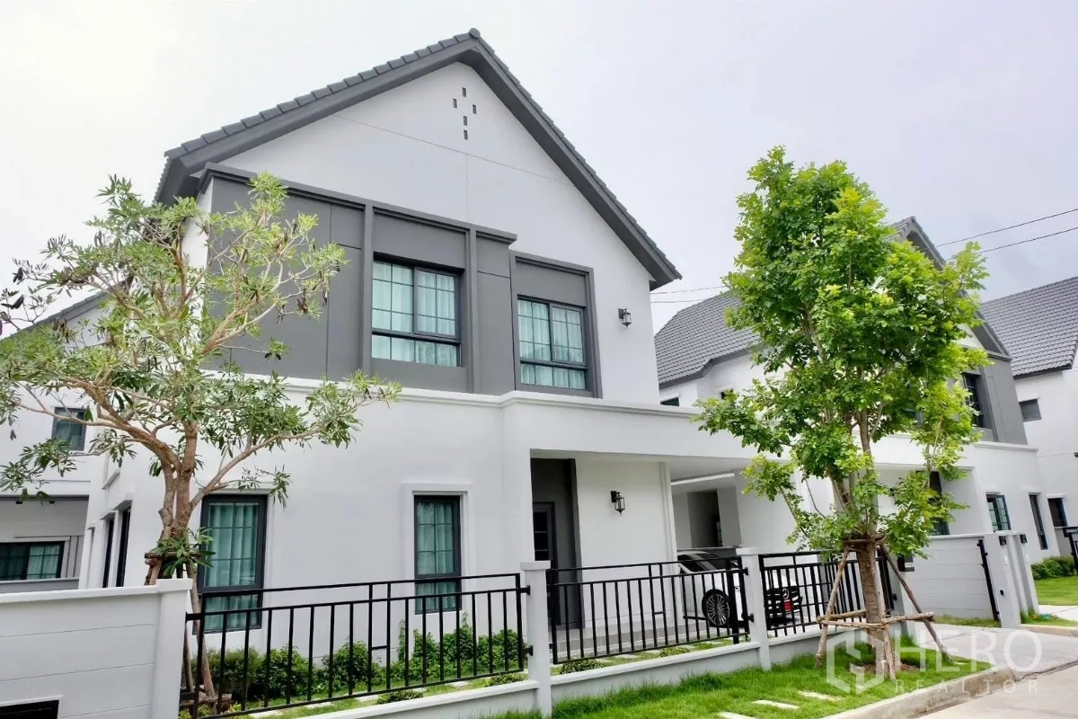独立式住宅 出售在Bang Phli, Samut Prakan - 独栋别墅街角外观视角，双坡屋顶，草坪与围栏