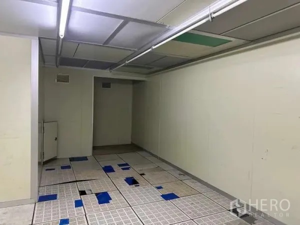 Factory for rent or sale in Thanyaburi, Pathum Thani - Cleanroom-style space with raised perforated flooring and strip lights.