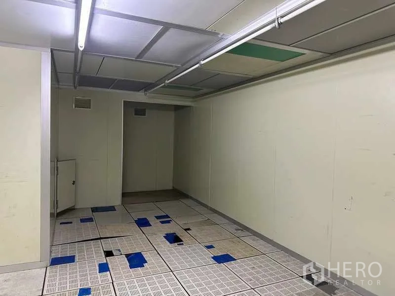 Factory for rent or sale in Thanyaburi, Pathum Thani - Cleanroom-style space with raised perforated flooring and strip lights.