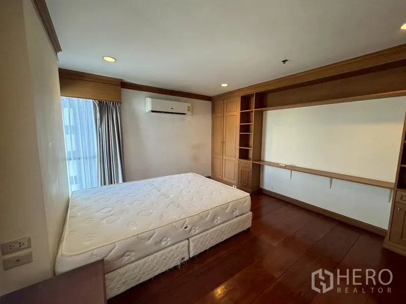 Condominium for rent in Watthana, Bangkok - Opposite view of the master bedroom showing built-in wardrobes and shelving.