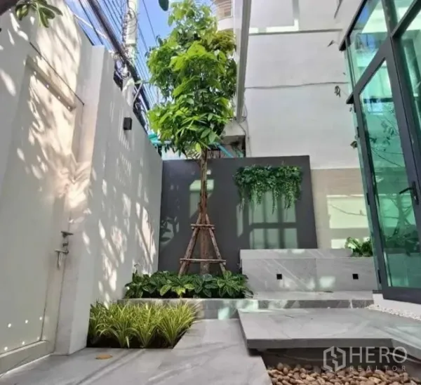 带办公室的家 出租在Suan Luang, Bangkok - 小型庭院景观，有树木、花坛、石径和玻璃门。