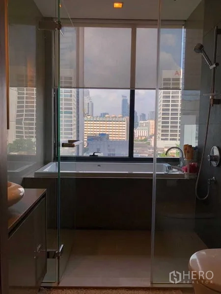 Condominium for rent in Bang Rak, Bangkok - Glass-enclosed shower facing a soaking tub with skyline views.